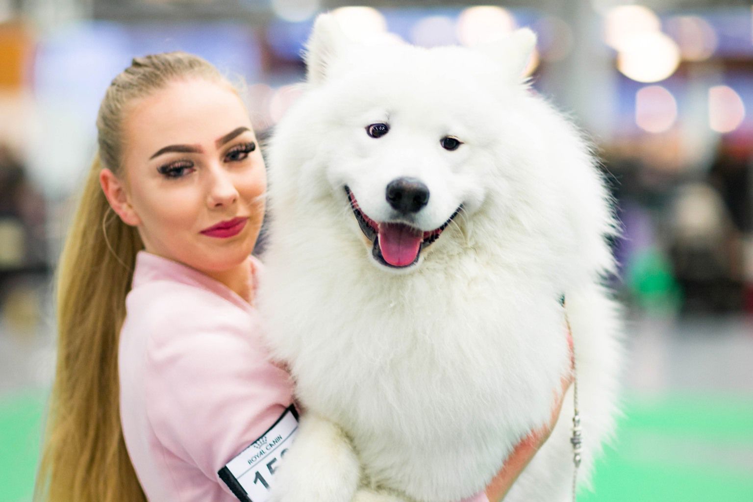 A proud dog mom lifts up her pup.