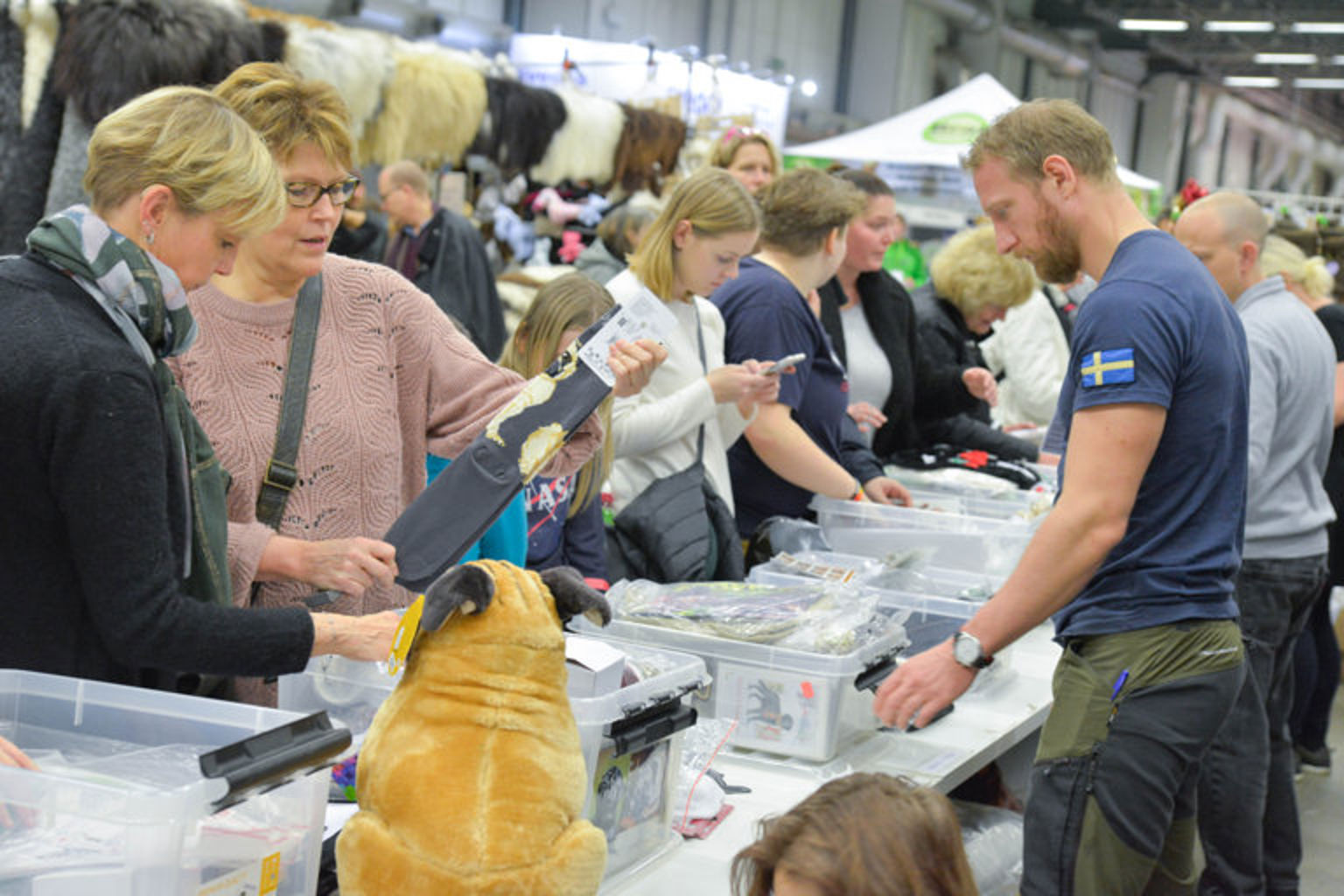 En grupp människor som spanar in produkterna i en monter på tillbehörsmässan.